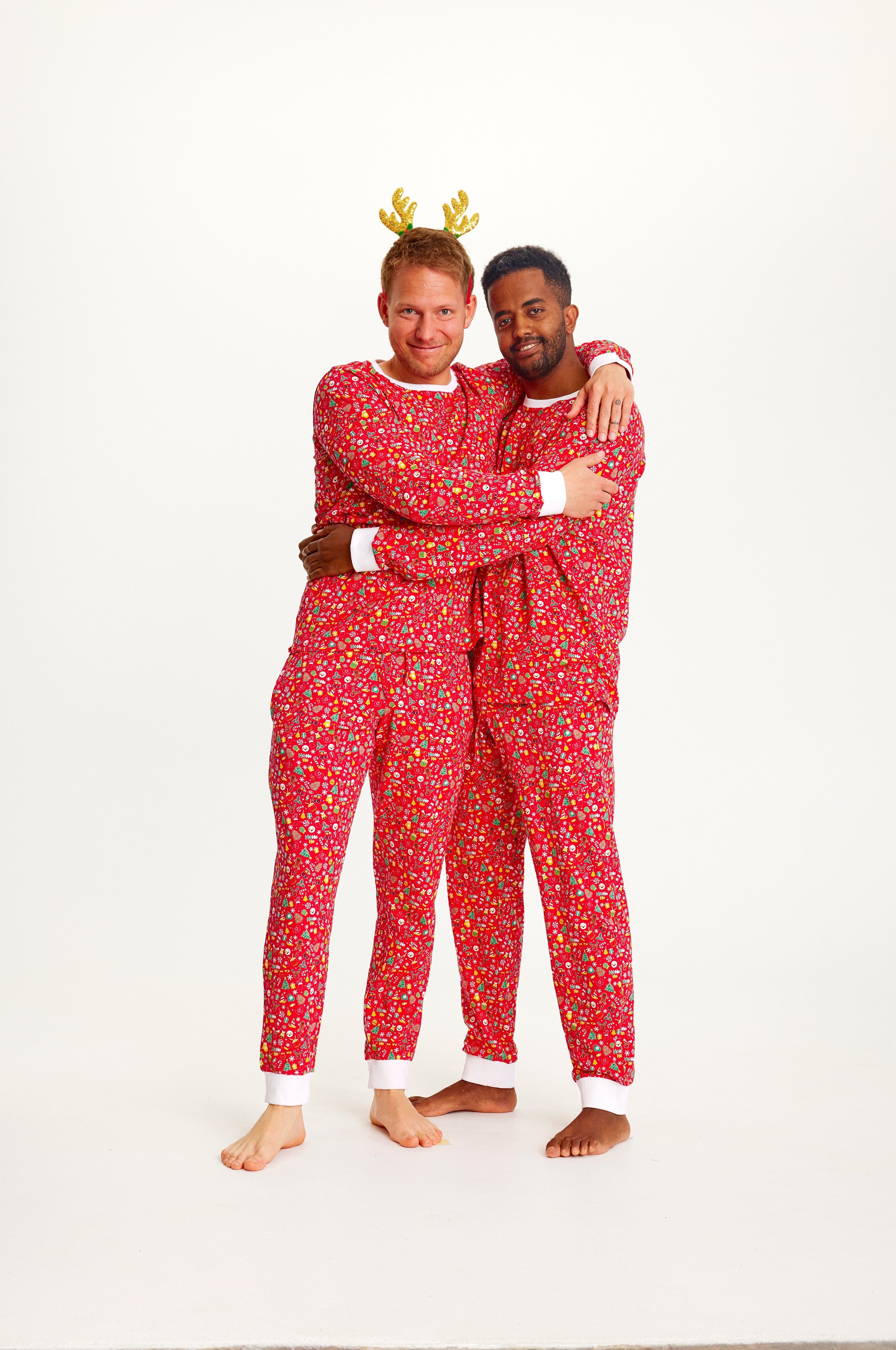 To mand holder om hinanden og poserer i hver deres røde julepyjamas.